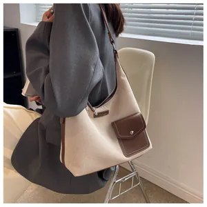 Vue détaillée du sac à bandoulière en toile et cuir avec sangle réglable et boucle