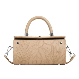 Detailed close-up of beige cylindrical bag with floral embossing and silver hardware