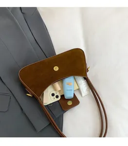 Detail of brown suede crescent bag showing spacious interior with magnetic closure