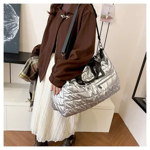 Détail d'un grand sac cabas matelassé argenté avec poignées noires dans un cadre moderne