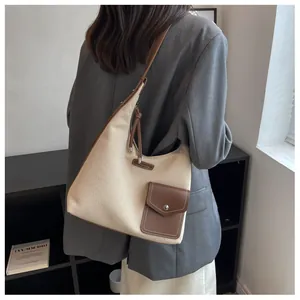 Détail des coutures en toile et cuir marron sur un grand sac fourre-tout élégant