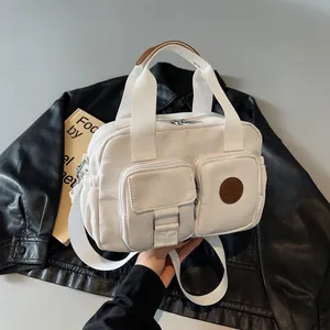 White nylon shoulder bag with multiple pockets and adjustable strap for women