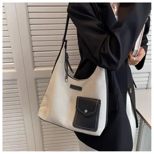 Détail du sac fourre-tout en toile avec patchwork en cuir noir et bandoulière réglable