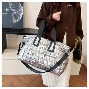 Détail du tissu matelassé argenté et de la bandoulière de ce grand sac fourre-tout