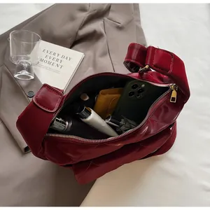 Deep red quilted dumpling bag showing interior capacity with phone and cosmetics