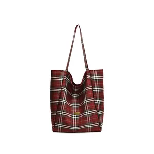 Classic red plaid canvas tote bag with large capacity and gold logo plaque on white background