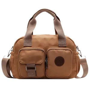 Brown canvas crossbody bag with multiple front pockets and adjustable shoulder strap