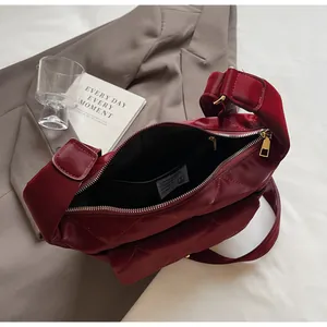 Detail view of the quilted dark red shoulder bag showing inner pocket and gold hardware