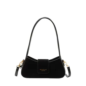 Elegant black crescent shoulder bag featuring suede patchwork and gold buckle details