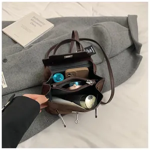 Detailed interior of dark brown velvet Kelly bag showing multi-layer storage compartments