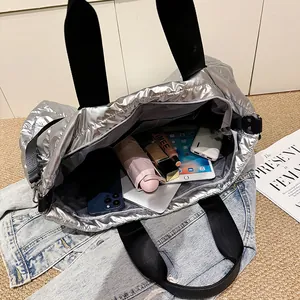 Grand sac cabas matelassé argenté montrant un intérieur spacieux et des accessoires