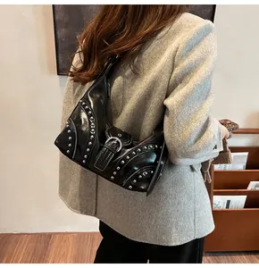 Détail d'un sac hobo noir mat avec clous argentés et boucles dans un style punk rock