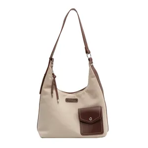 Sac seau en toile crème avec bandoulière en cuir marron et poche avant décorative