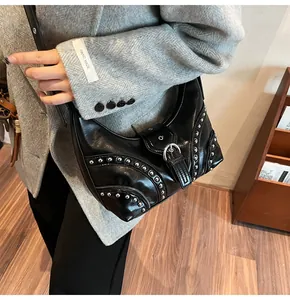 Détail du sac dumpling en cuir noir avec rivets en métal argenté et sangle à boucle
