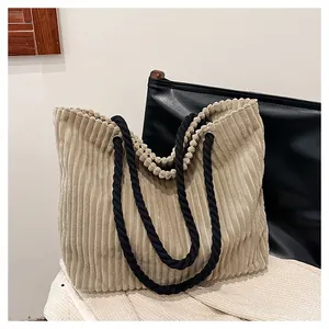 Détail du sac fourre-tout en velours côtelé beige avec poignées en corde noire et anneaux