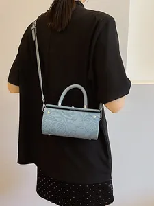 Retro light blue cylindrical bag with floral embossing and leather shoulder strap