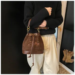 Detail of plush brown bucket bag with leather drawstring and embroidered 24 logo