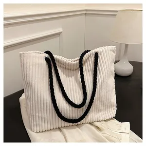 Détail d'un cabas en velours côtelé blanc avec texture rayée et anses en corde tressée