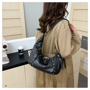 Detail view of black vintage leather hobo bag with gold studs and decorative buckle