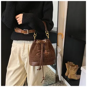 Detail of plush brown bucket bag showing drawstring closure and embroidered 23 logo