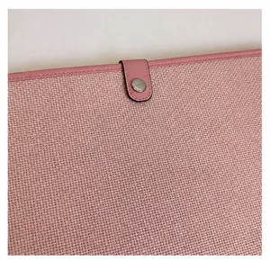 Detail of pink canvas fabric texture and silver metal snap button on the document bag
