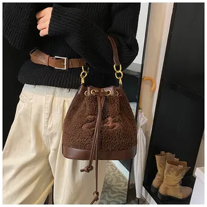 Detail of brown faux shearling bucket bag with leather drawstring and gold hardware