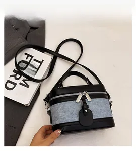 Detail view of the black leather and blue denim patchwork design with dual zippers