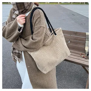 Détail du sac cabas en velours côtelé beige avec anses tressées et œillets en argent