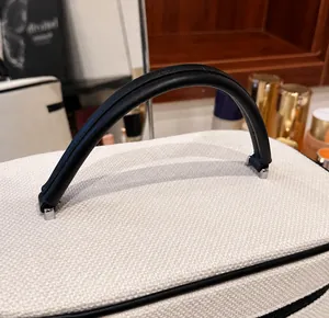 Dettaglio della trama in tela intrecciata e del robusto manico in pelle nera della borsa