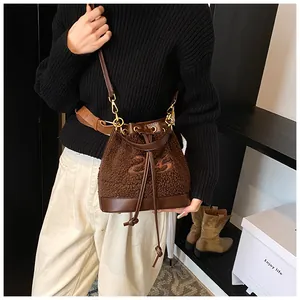 Close-up of brown plush bucket bag with leather drawstring and number 25 embroidery