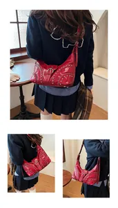 Détails du sac hobo en cuir verni rouge avec rivets argentés et accents de style rock