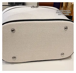 Dettaglio del fondo della borsa in tela con rivetti in argento antigraffio e usura