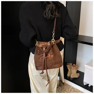 Brown plush bucket bag detail showing leather patchwork and embroidered pattern