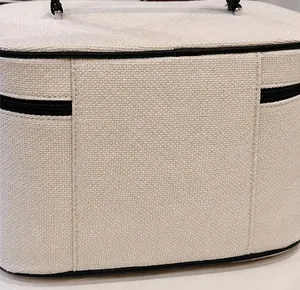 Dettaglio del tessuto in tela beige di qualità e finiture in pelle nera della borsa