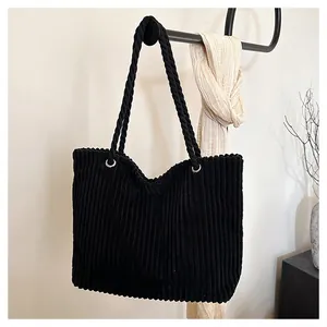 Détail du sac cabas en velours côtelé noir montrant la texture et les anneaux en métal