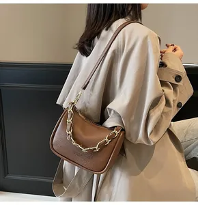 Vue détaillée du sac en cuir grainé marron avec une chaîne décorative en métal doré