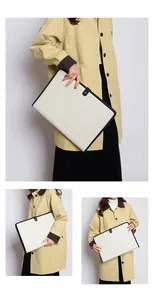 Pochette porte-documents en toile avec liseré noir portée par un mannequin avec élégance