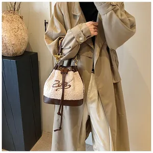 Detail of plush faux shearling and brown leather bucket bag with 2023 embroidery