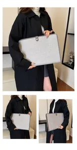 Détail du porte-documents en toile grise montrant le bouton-pression et les coutures