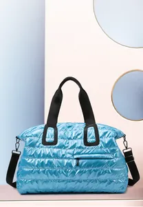 Macro shot of light blue quilted fitness bag showing waterproof fabric and zipper pocket