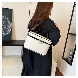 Elegante borsa a scatola bianco off-white con manici neri e tracolla su modella