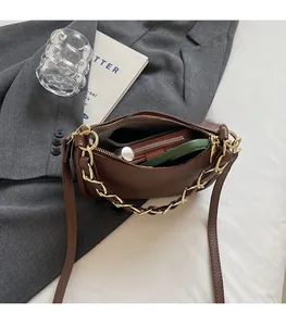 Vue de dessus d'un sac bandoulière en cuir marron montrant un intérieur spacieux et des objets