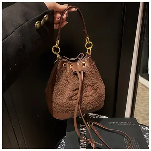 Detailed macro of plush brown bucket bag with leather strap and gold hardware rings