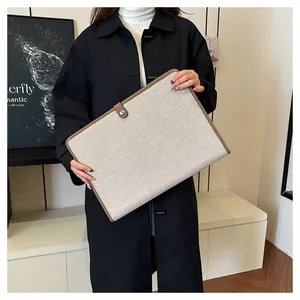 Détail du sac de bureau en toile avec bordure en cuir marron et fermeture à bouton