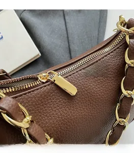 Détail d'un sac à main en cuir marron avec fermeture éclair dorée et bandoulière
