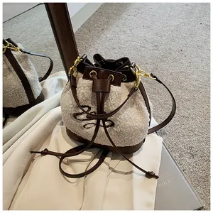 Detailed close-up of plush teddy fleece bucket bag with brown leather drawstring trim