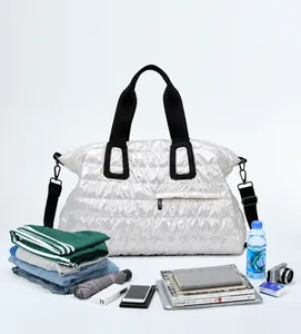 Macro view of silver quilted travel bag showing large capacity storage for clothes and gear