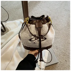 Detail of plush lamb wool bucket bag featuring leather trim and drawstring closure