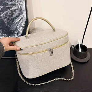 Dettaglio della trama intrecciata e della catena in metallo su questa borsa beige elegante
