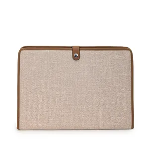 Détail du sac à documents en toile avec bordure en cuir marron et fermoir métallique